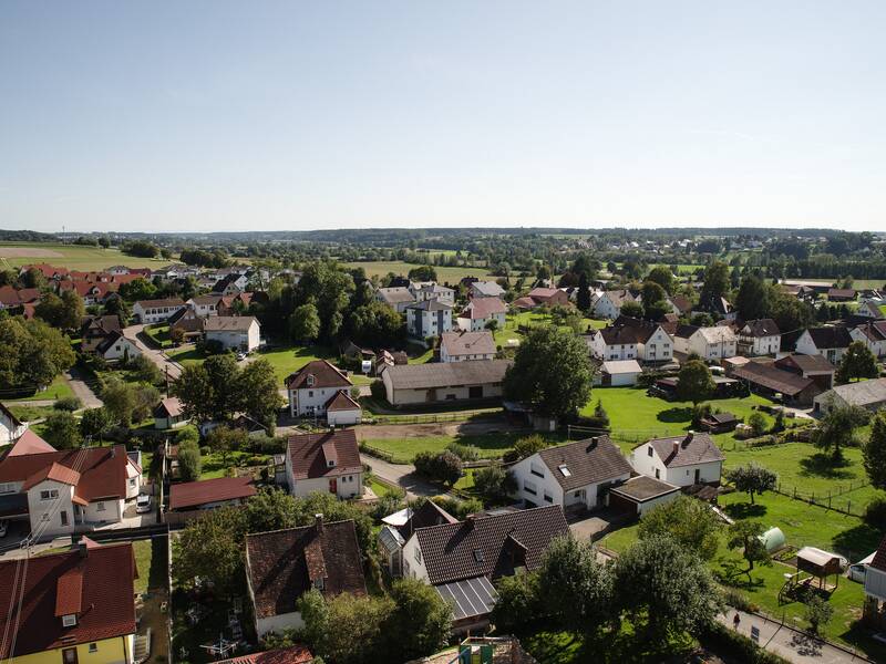 Luftbild von Orsenhausen, Blickrichtung Schwendi und Bußmannshausen . Im Vordergrund viele kleine Häuser, Schuppen und Bäume. Im Hintergrund ist ein Ort zu erahnen sowie ein Wald zu sehen.