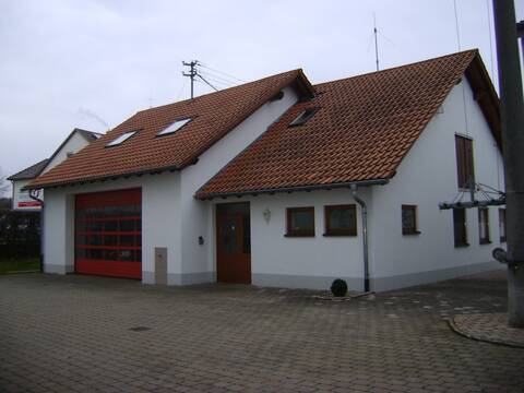 Bild des Feuerwehrgerätehaus in Orsenhausen. Links ist ein großes Garagentor zu sehen. Rechts der etwas kleinere Sozialtrakt des Gebäudes.