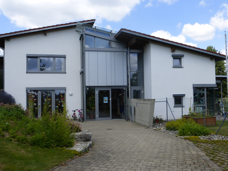 Kindergartengebäude auf grüner Wiese