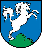 Wappen: Auf blauem Grund auf drei grünen Hügeln ein nach rechtshin steigendes  weißes Pferd.